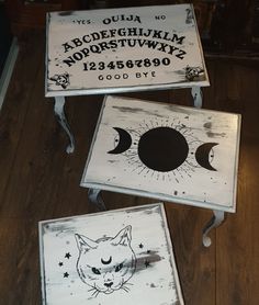 three wooden signs with cats and moon designs on them sitting on the floor next to each other