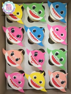 cupcakes decorated to look like sharks with their mouths open and teeth out, in a box