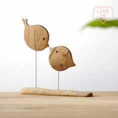 two wooden birds sitting on top of each other