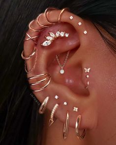 a woman's ear with different types of piercings