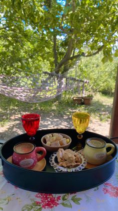 a tray that has some cups and saucers in it on top of a table