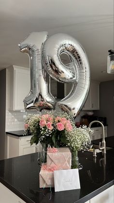 a table with flowers and balloons in the shape of numbers