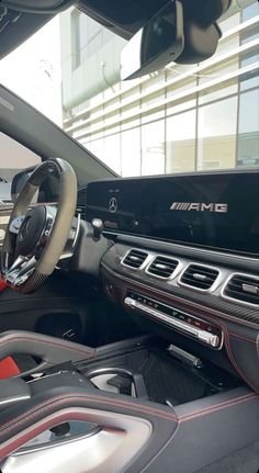 the interior of a car with red stitching and leather trims, including steering wheel