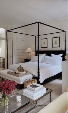 a bedroom with a four poster bed and white walls