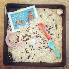 a tray filled with sand and toys on top of a table