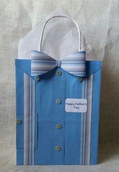 a paper bag with a blue shirt and bow tie on it that says happy father's day