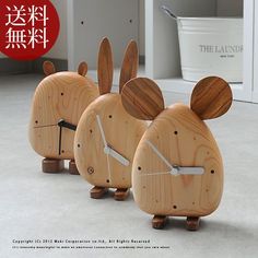 three wooden clocks shaped like mice on the floor