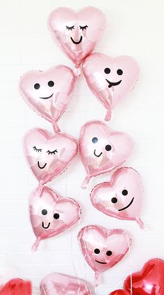 pink heart shaped balloons with faces drawn on them