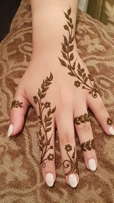 a woman's hand with henna tattoos on it