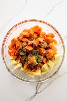 a glass bowl filled with chopped carrots and potatoes