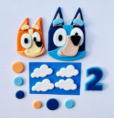 two cookies made to look like cartoon characters with clouds in the shape of faces and numbers