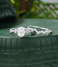 a diamond ring sitting on top of a green tire treading surface with greenery in the background