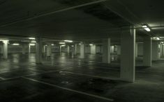 an empty parking garage with no people or vehicles in the area and lights shining on the floor