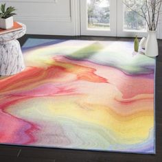 a multicolored area rug in front of a white door with potted plants