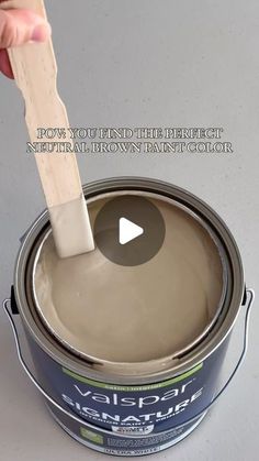 a person is holding a paint brush over a can of gray paint with the words, how to use the perfect neutral brown paint color