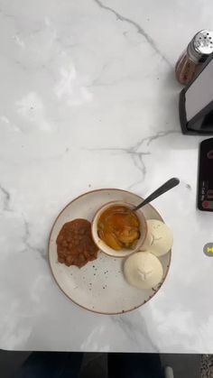 a white plate topped with food on top of a counter next to a blender