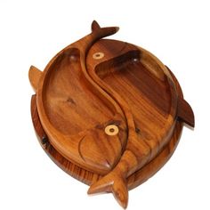 two wooden fish shaped dishes on top of each other