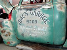 an old green truck parked on the street