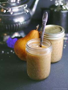 two jars filled with food sitting on top of a table next to a silver teapot