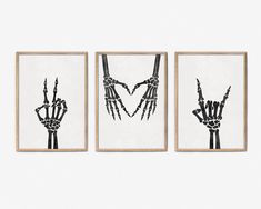 three black and white art prints with hands holding up the same hand, on a wall