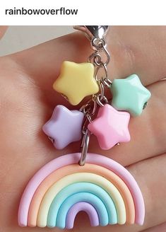 a hand holding a rainbow key chain with stars and a star on the top of it