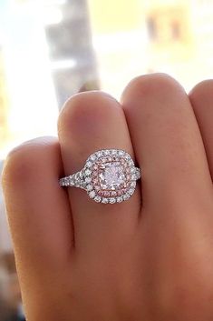 a woman's hand with a diamond ring on top of her finger and an engagement band