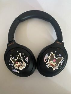 two black headphones with stickers on them