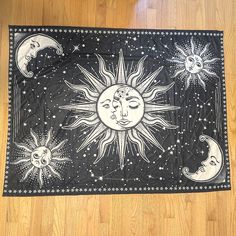 the sun and moon are depicted in this black and white painting on a wood floor