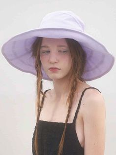 a woman wearing a purple hat and black dress