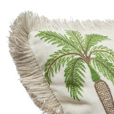 a pillow with a palm tree on it and fringes around the edges is shown