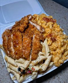 a white plate topped with pasta and chicken next to macaroni