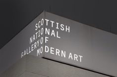 an illuminated sign on the side of a building that says scottish national gallery of modern art