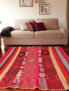 a living room with a couch, rug and pictures on the wall