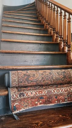 an old carpeted stair case with wooden balconies and handrails in a home