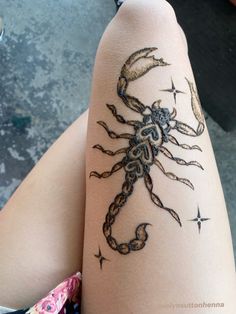 a woman's leg with a tattoo on it that has a scorpion drawn on it