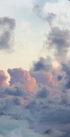 the sky is filled with clouds and boats