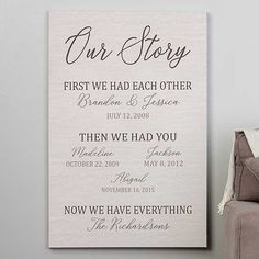 a canvas with the words our story written on it next to a chair and throw pillow