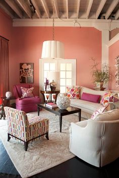 a living room with pink walls and furniture