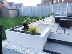 an outdoor patio area with stone steps and plants in the planter, surrounded by grass