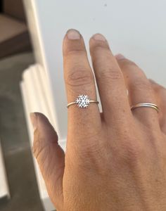 a woman's hand wearing a ring with a star design on the middle finger