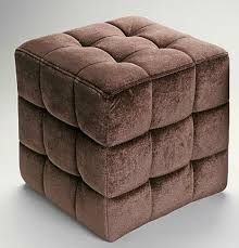 a brown square ottoman sitting on top of a white floor