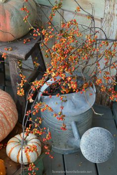 pumpkins and gourds are sitting on the porch