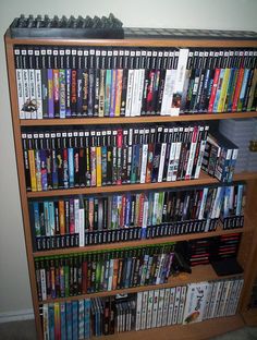 a bookshelf filled with lots of different types of dvd's and dvds