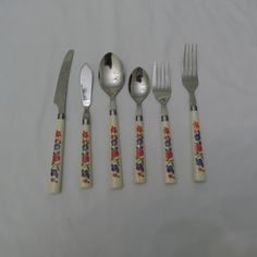 five silverware pieces with flowers on them are lined up next to each other, including forks and spoons