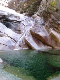 the water is green and clear in this rocky area with large rocks on either side