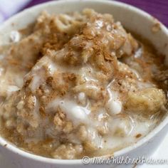 a white bowl filled with oatmeal covered in toppings on top of a table