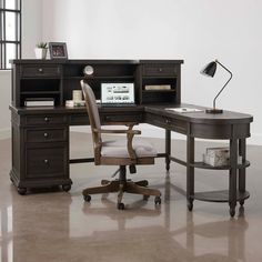 an office desk with a chair and computer on it