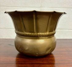 a gold vase sitting on top of a wooden table