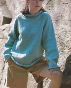 a woman in a blue sweater and tan shorts