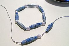 a blue beaded bracelet sitting on top of a table next to a computer mouse